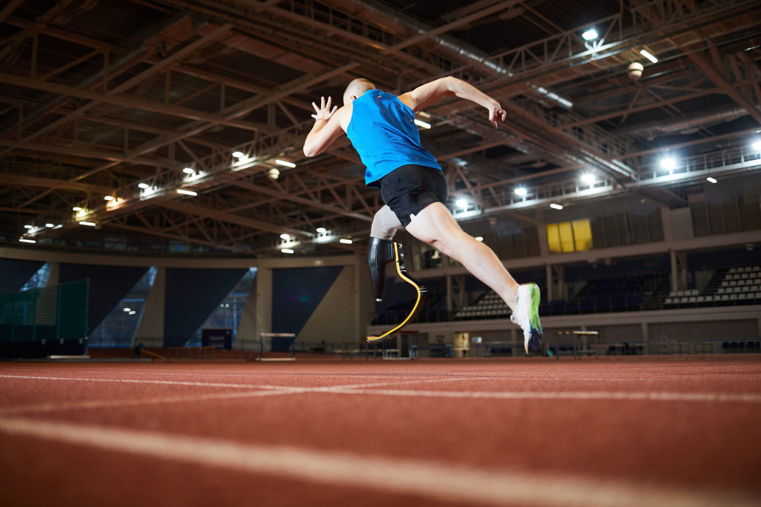 Sprinter med benprotese på innendørs løpebane.