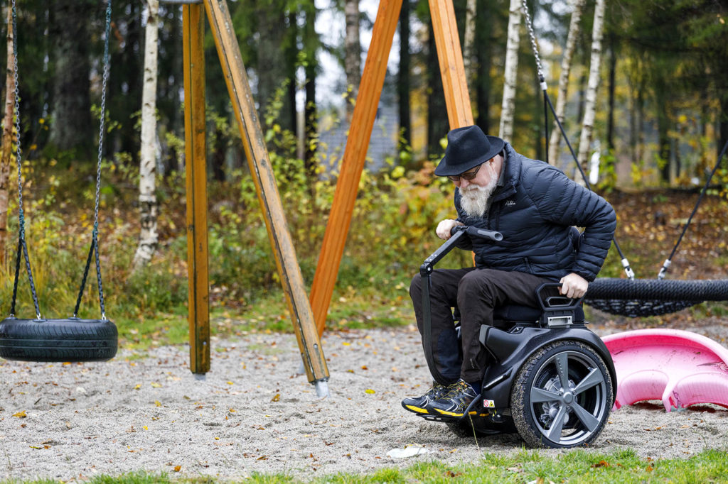 Oddgeir tar seg fram med en Genny på en lekeplass.