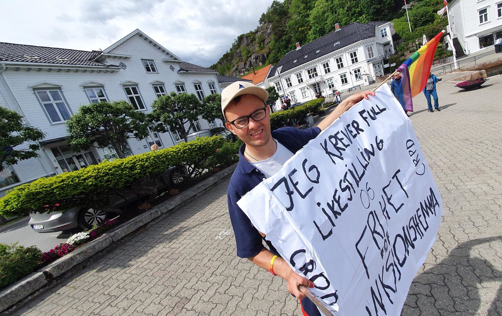 Andreas Haugland fotografert mens han holder opp en plakat med teksten «Jeg krever full likestilling og friet for funksjonshemma».