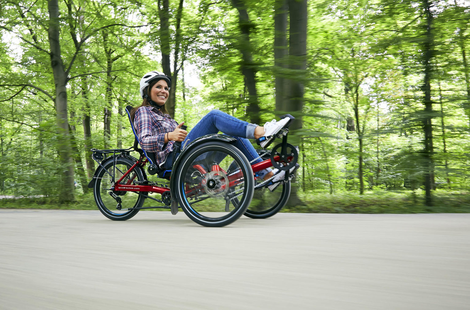 Bilde av kvinne som sykler på en liggesykkel.