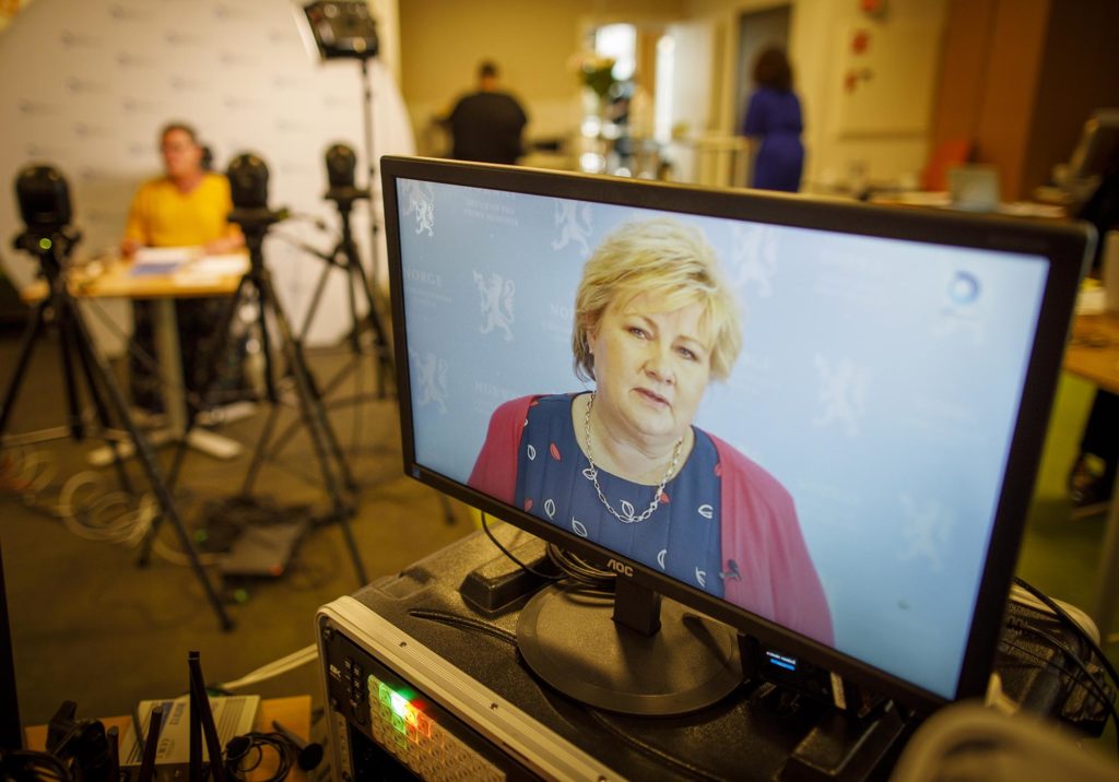 Bilde av en dataskjerm med bilde av Erna Solberg. Studioet i bakgrunnen.