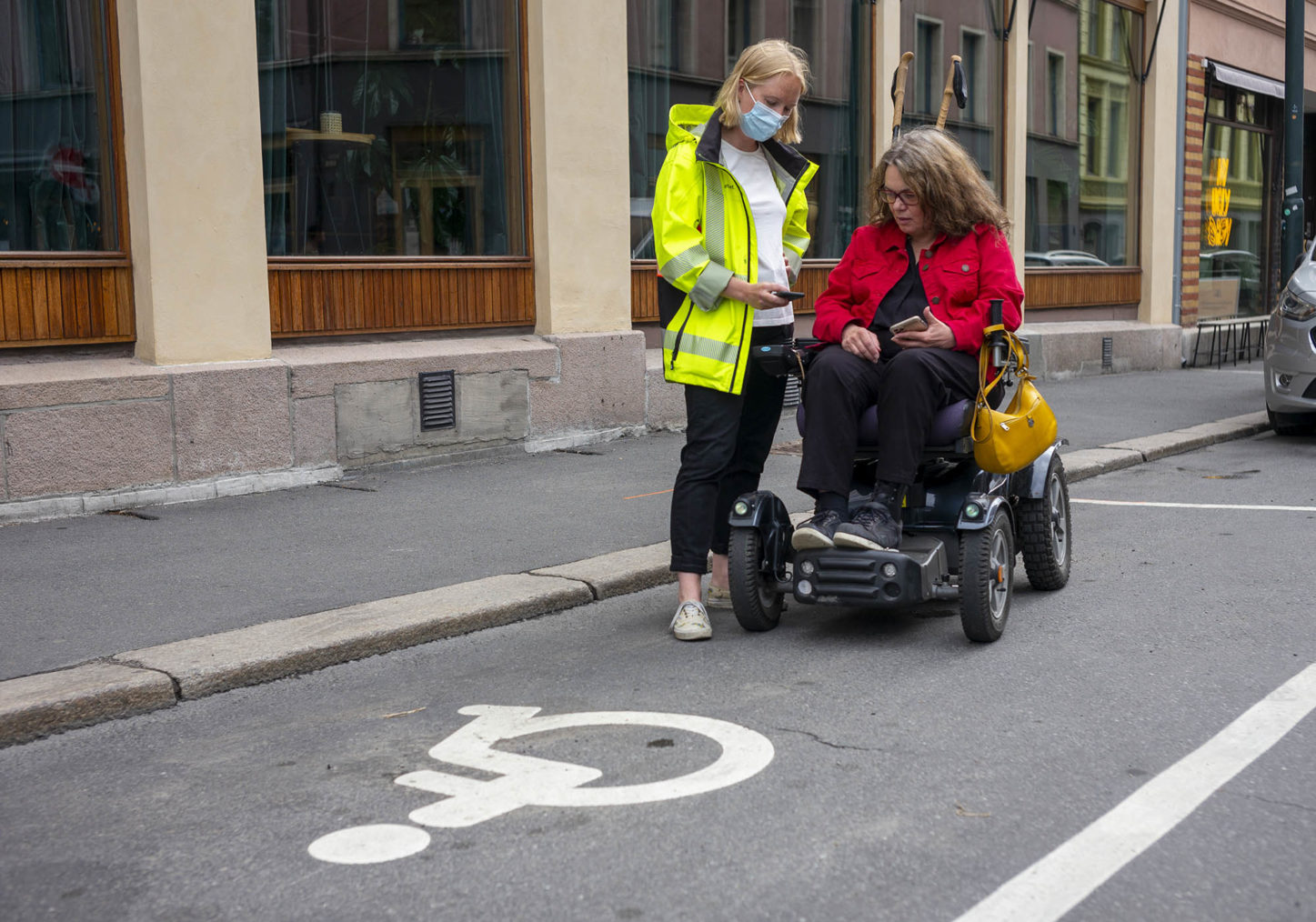 De to ser på en app sammen på en ledig HC-plass. Sørbotten i elektrisk rullestol.