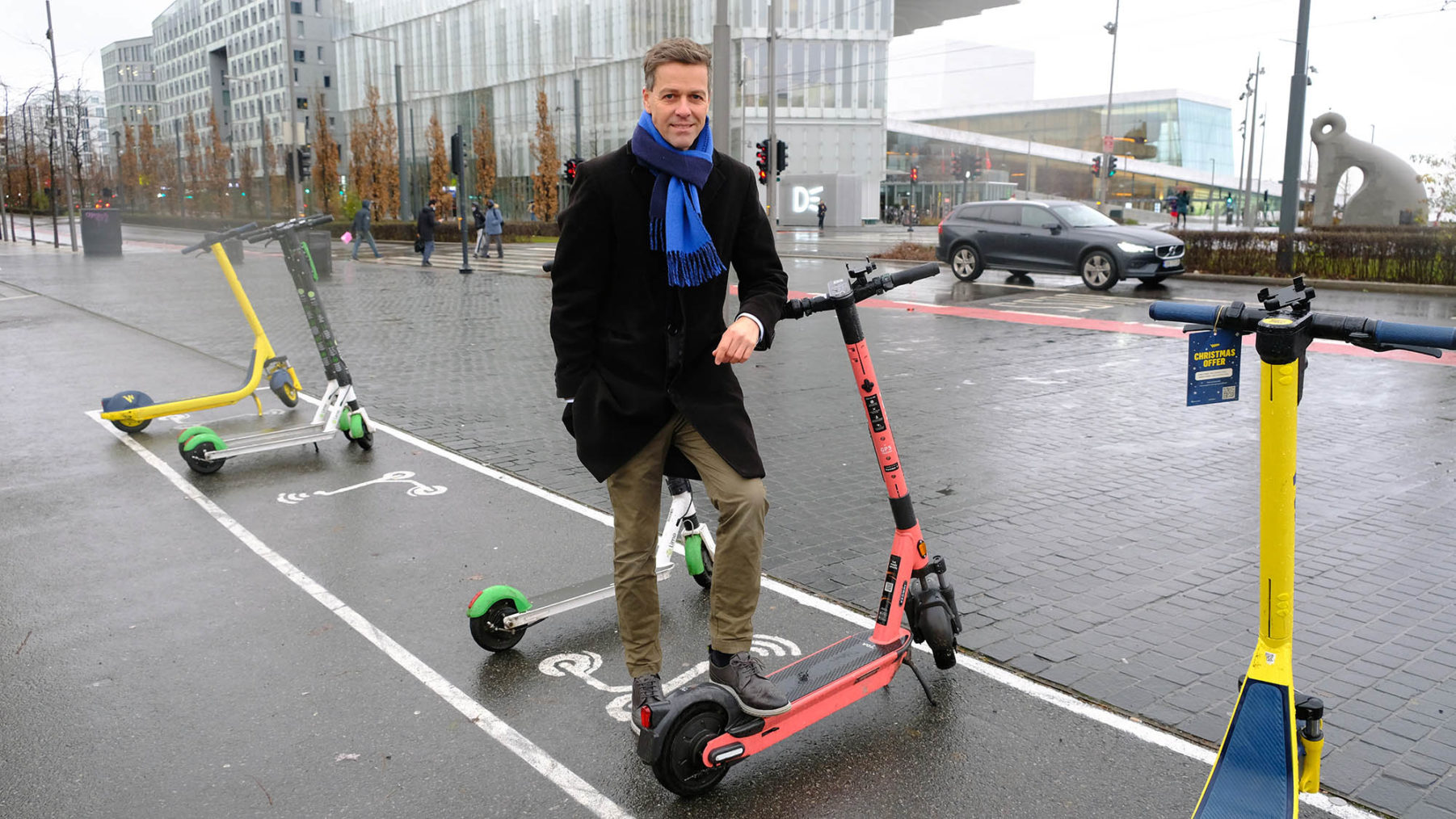 Hareide poserer ved parkerte elsparkesykler.