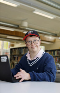 Lars Jakob sitter ved pc-en sin i biblioteket på skolen.