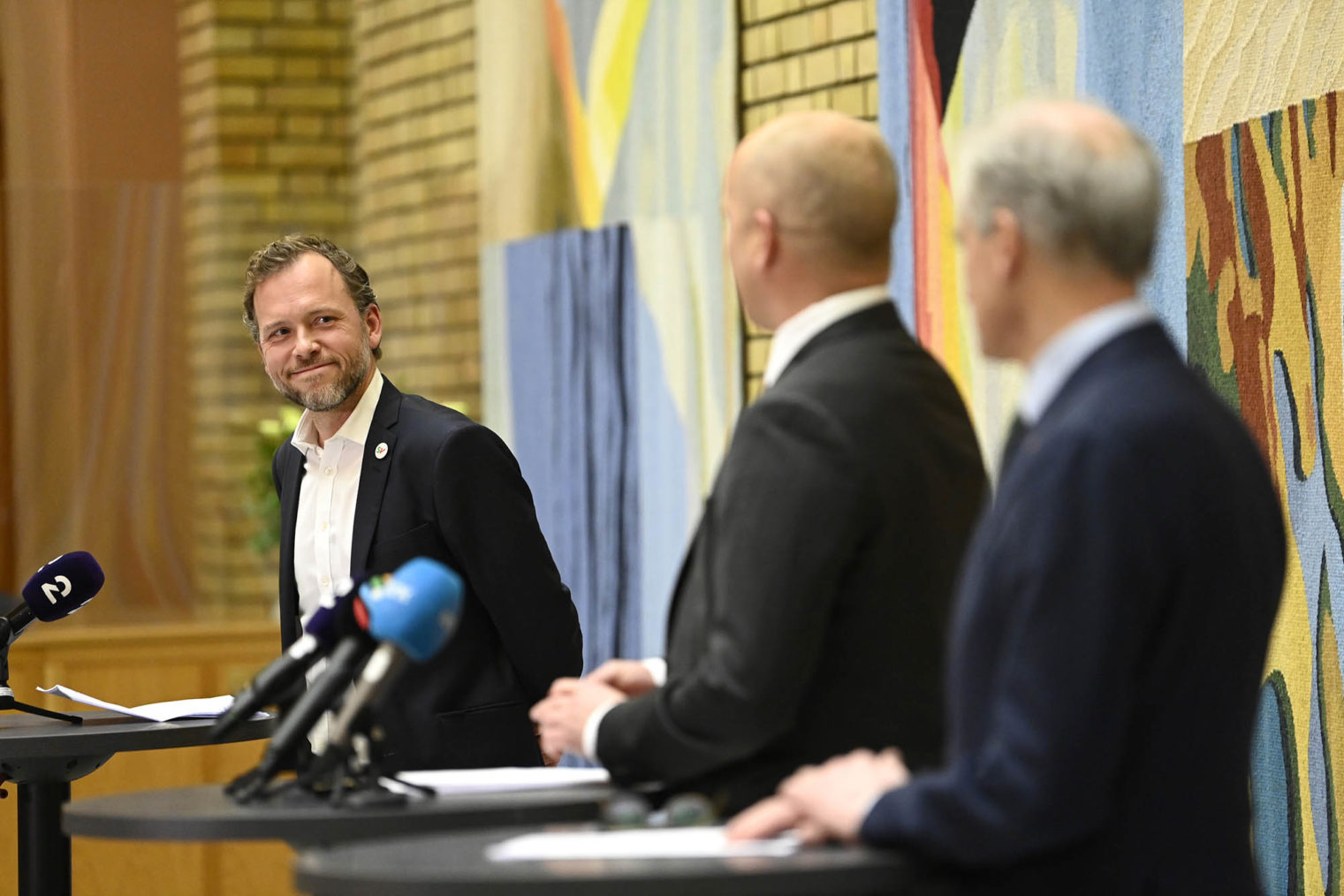 Audun Lysbakken smiler mot Jonas Gahr Støre og Trygve Slagsvold Vedum under pressekonferansen i Stortinget.