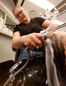 Benedicte vasker håret på en kunde.