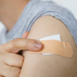 Coronavirus Vaccination concept. Adhesive bandage on man arm after vaccine injection. Covid-19 immunization program. Prevention, treatment and protection from coronavirus