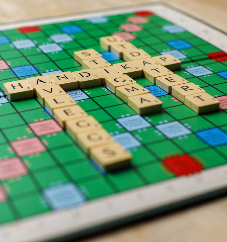 Bilde av et Scrabble-spill der ordet «handikap» er lagt i kombinasjon med ordene «utdatert», «stigma» og «avleggs».