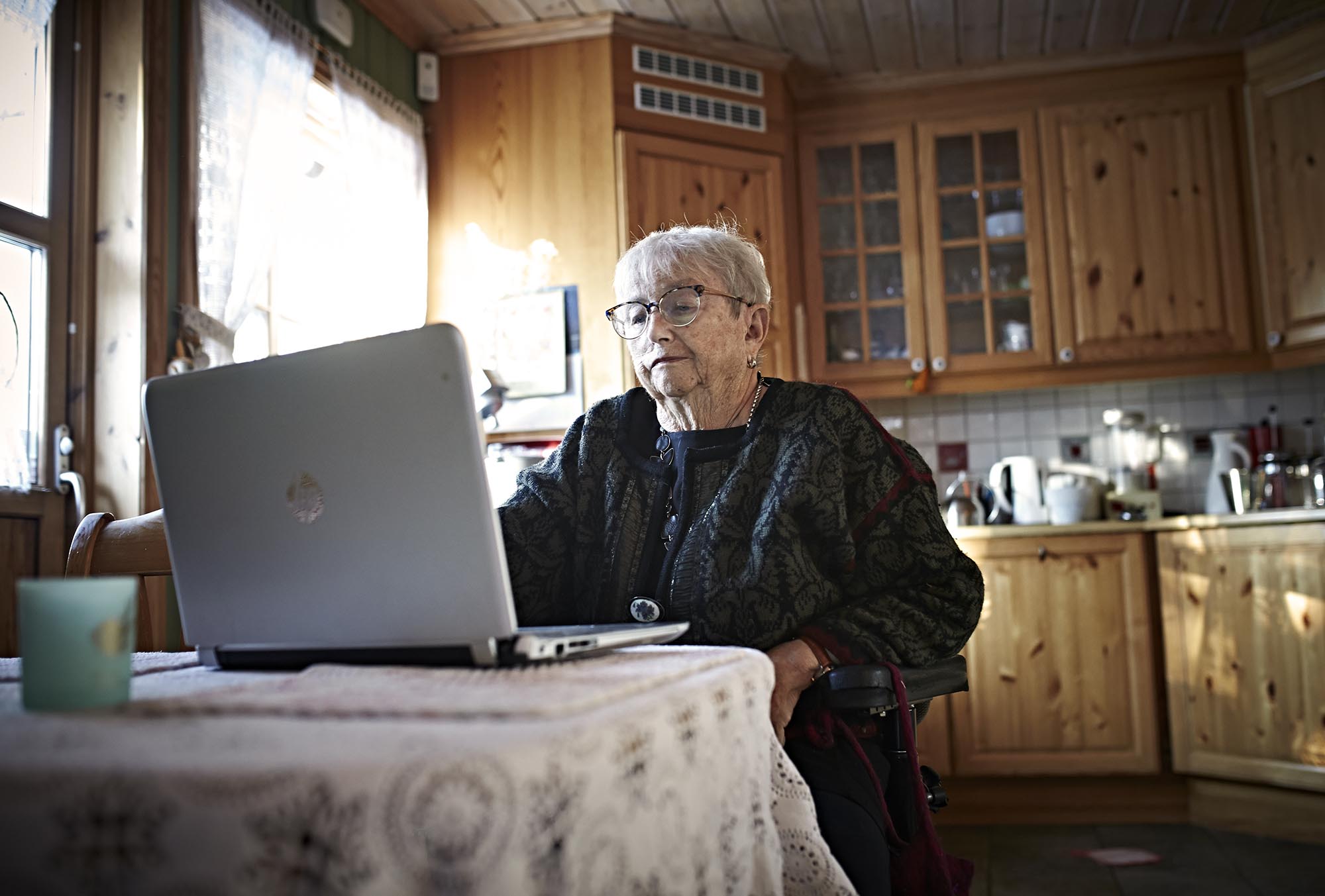 Unni sitter ved PC-en på kjøkkenet.