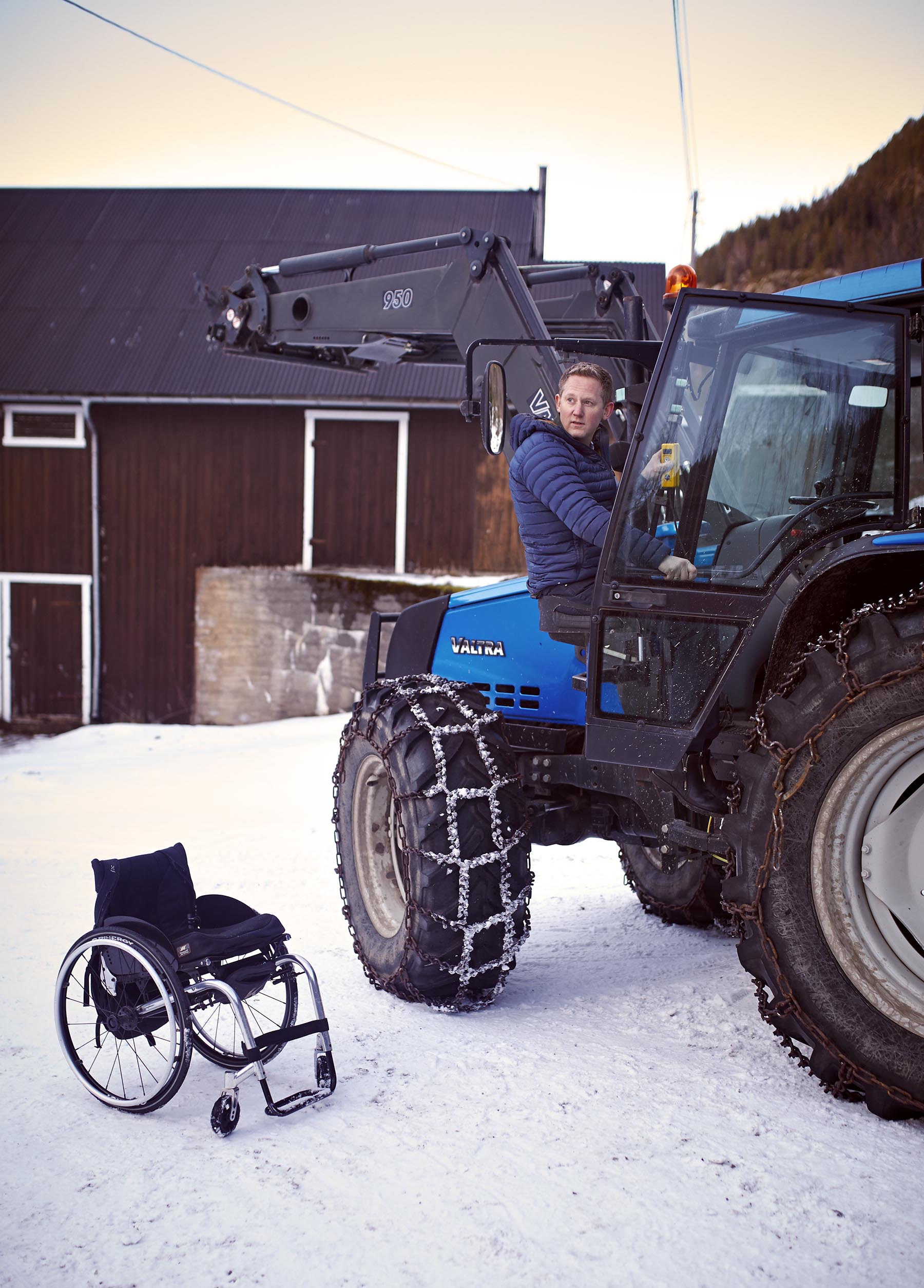 Arne på vei inn i traktoren med setelift. Rullestolen står igjen utenfor.