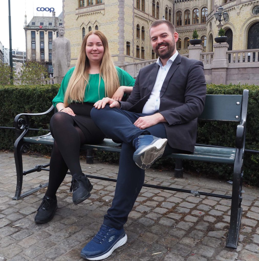 De to sitter sammen på en benk utenfor Stortinget.