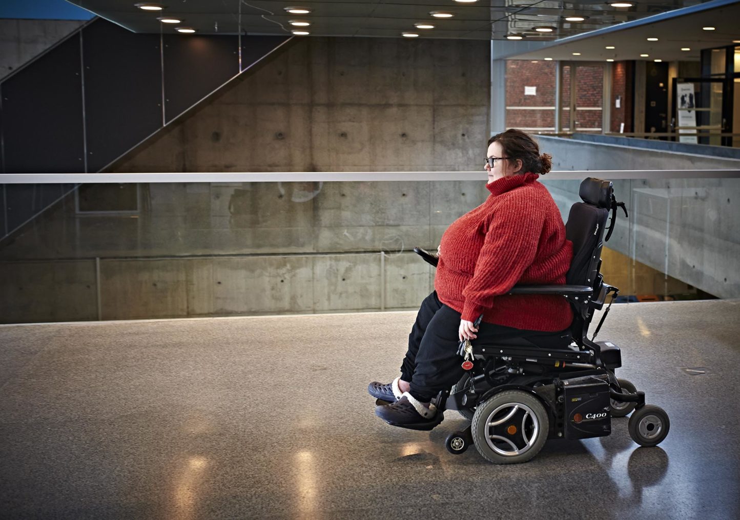 Sarah Naomi i elektrisk rullestol inne på høgskolen.