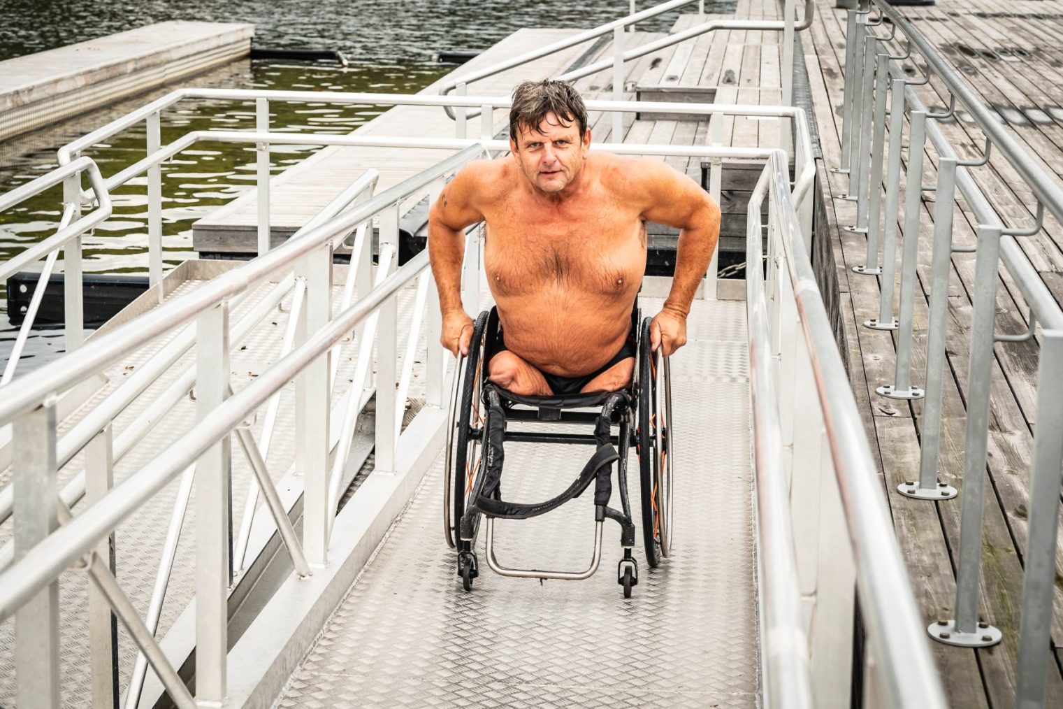 Atle Haglund i rullestol på vei opprampene fra badebingen på Sørenga