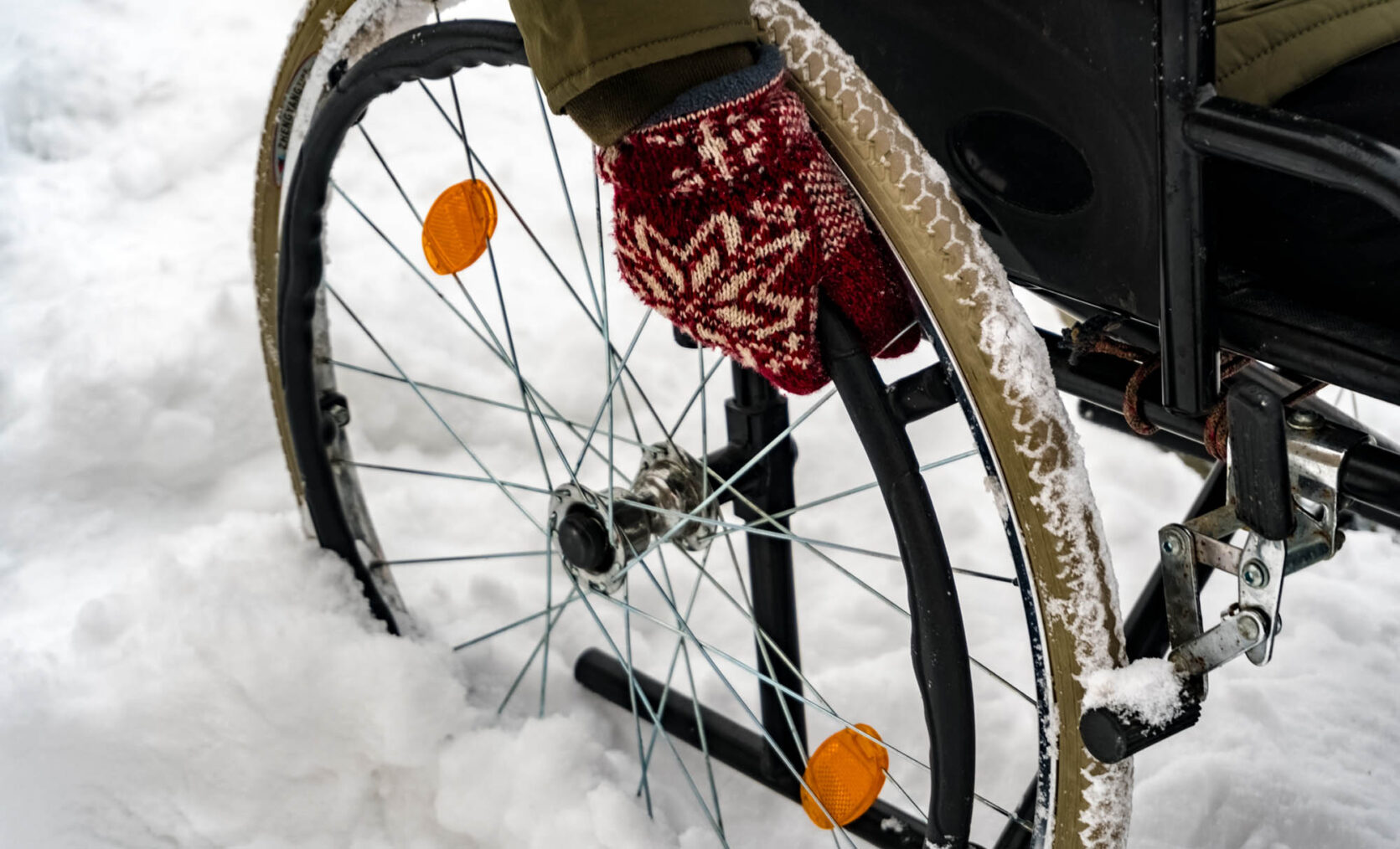 Nærbilde av rullestolhjul i snø.