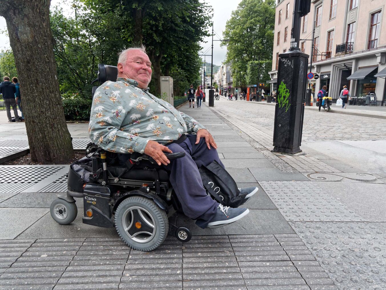 Egil Hope i elektrisk rullestol på gaten i Bergen sentrum.
