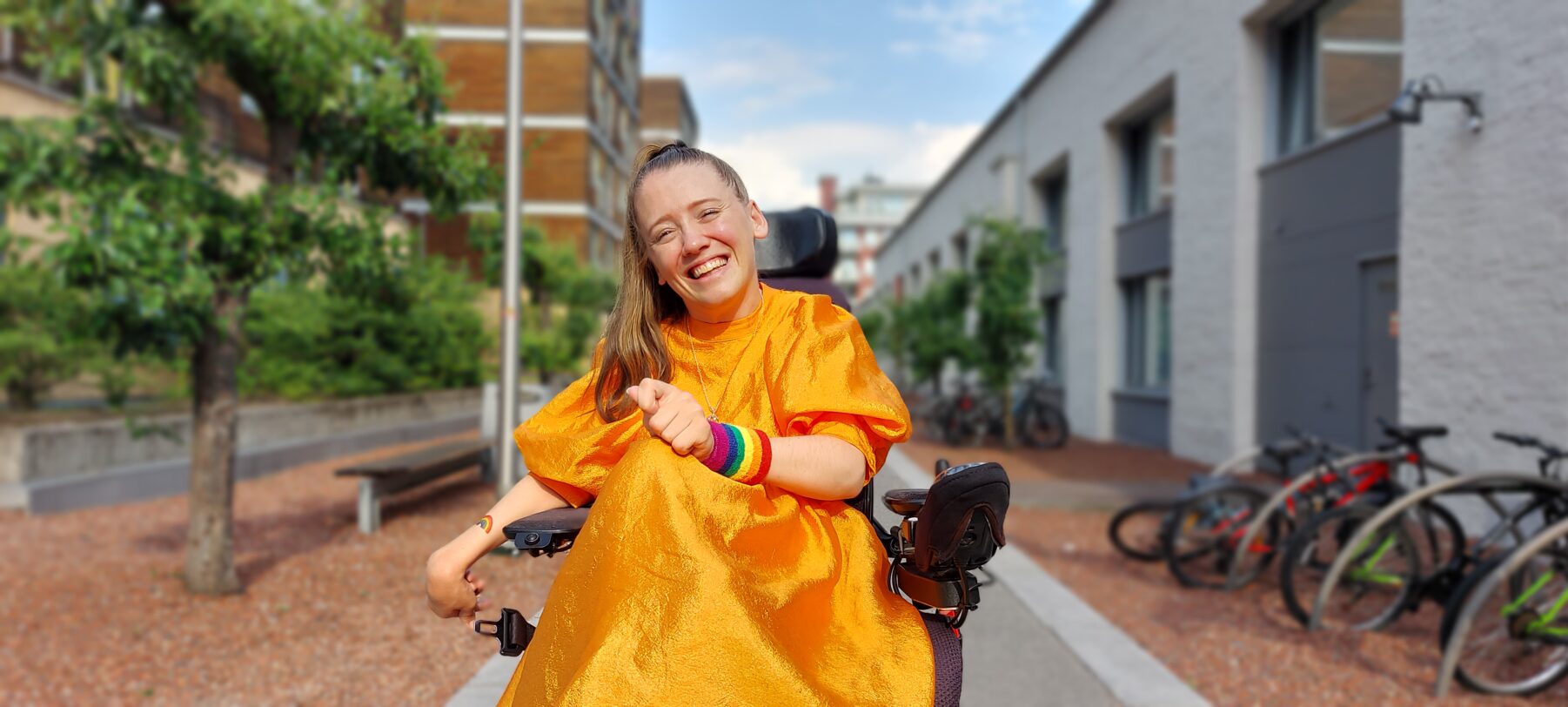 Ida Hauge Dignes i rullestol i gatemiljø, smiler mot kamera.