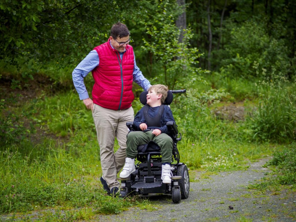 Far og sønn sammen, ser på hverandre og smiler.