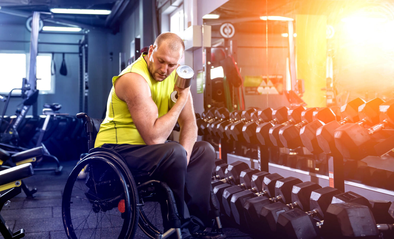 Illustrasjonsbilde av mann i rullestol som trener med vektmanualer i treningsstudio.