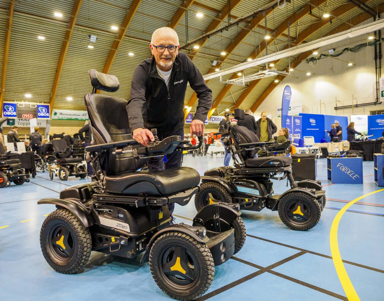 Sæle poserer med stolen i en messehall.