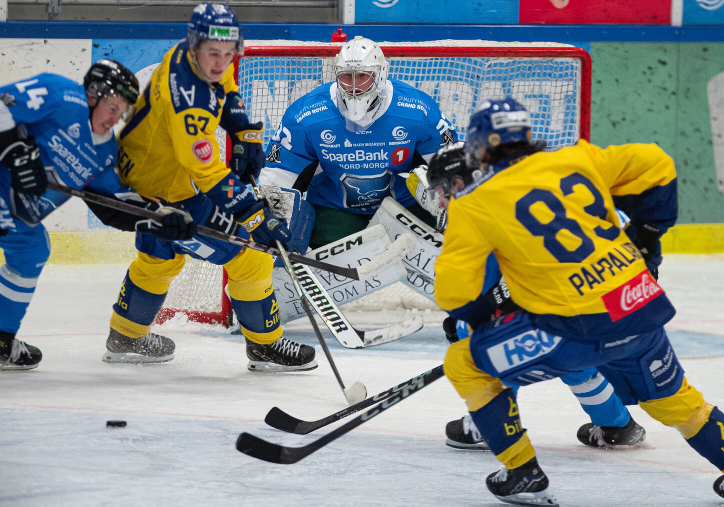 Ishockeyspillere med blå og gule drakter foran mål
