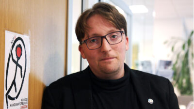 Mikkel Sibe ved dør med NHFU-logo