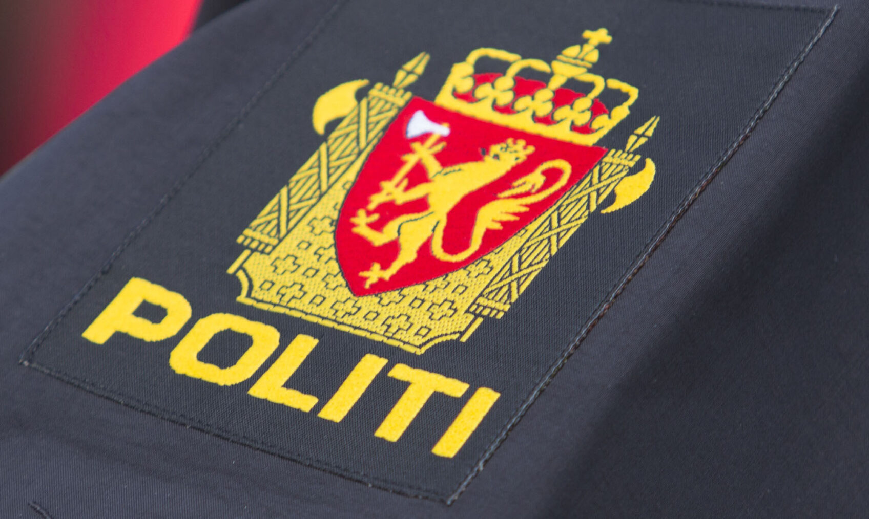 Politilogo med riksløven på uniform