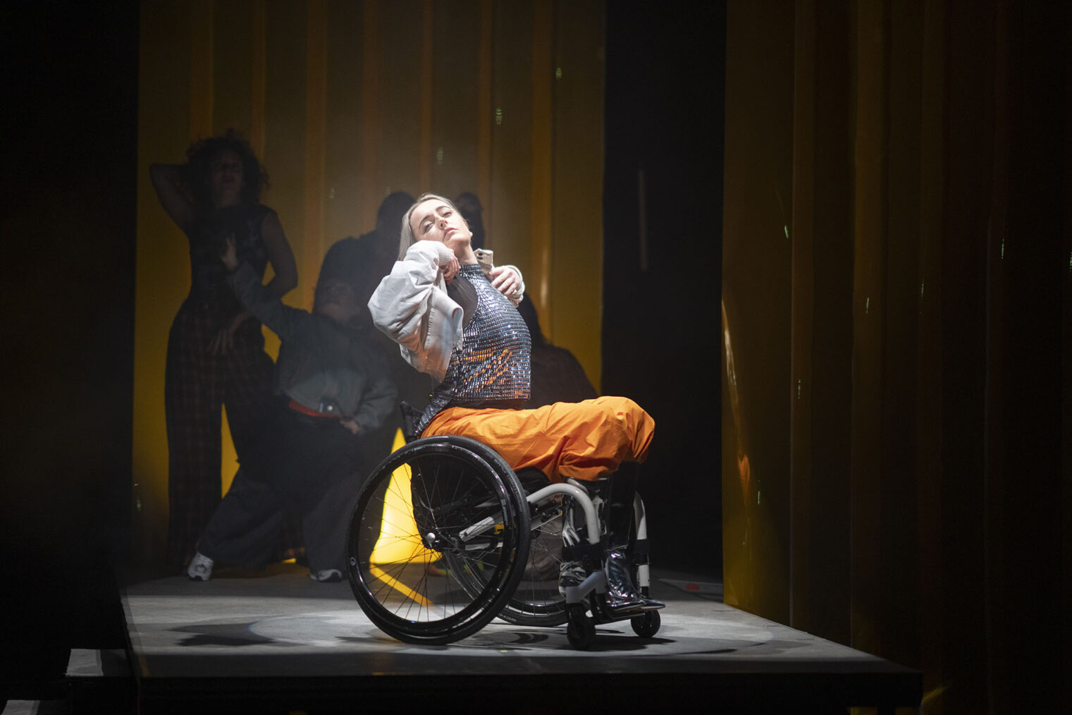Dansere på scenen, den fremste av dem i rullestol
