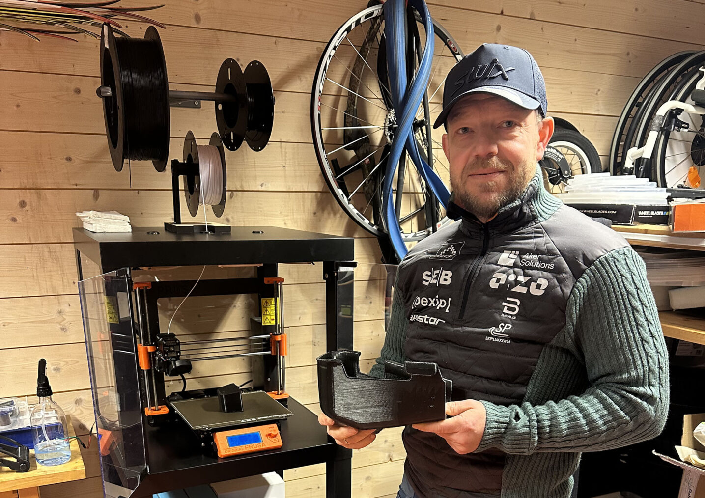 Viljar Aasan i verksted med ski, sykkelhjul og 3D-printer