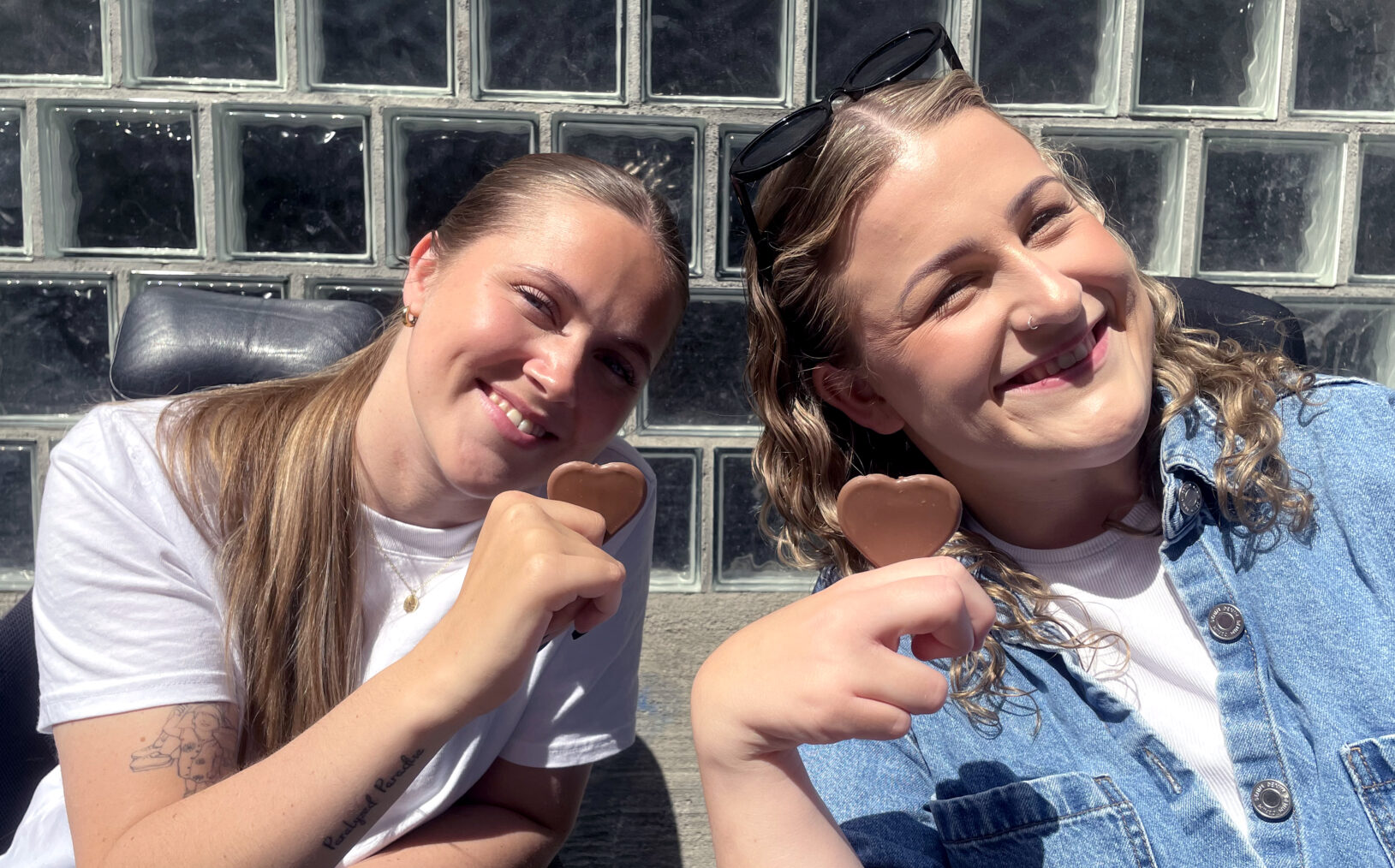 Hannah Lunden og Amalie Rakkestad smiler og holder hvert sitt melkesjokoladehjerte