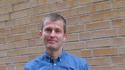 Christian Lupke foran murvegg