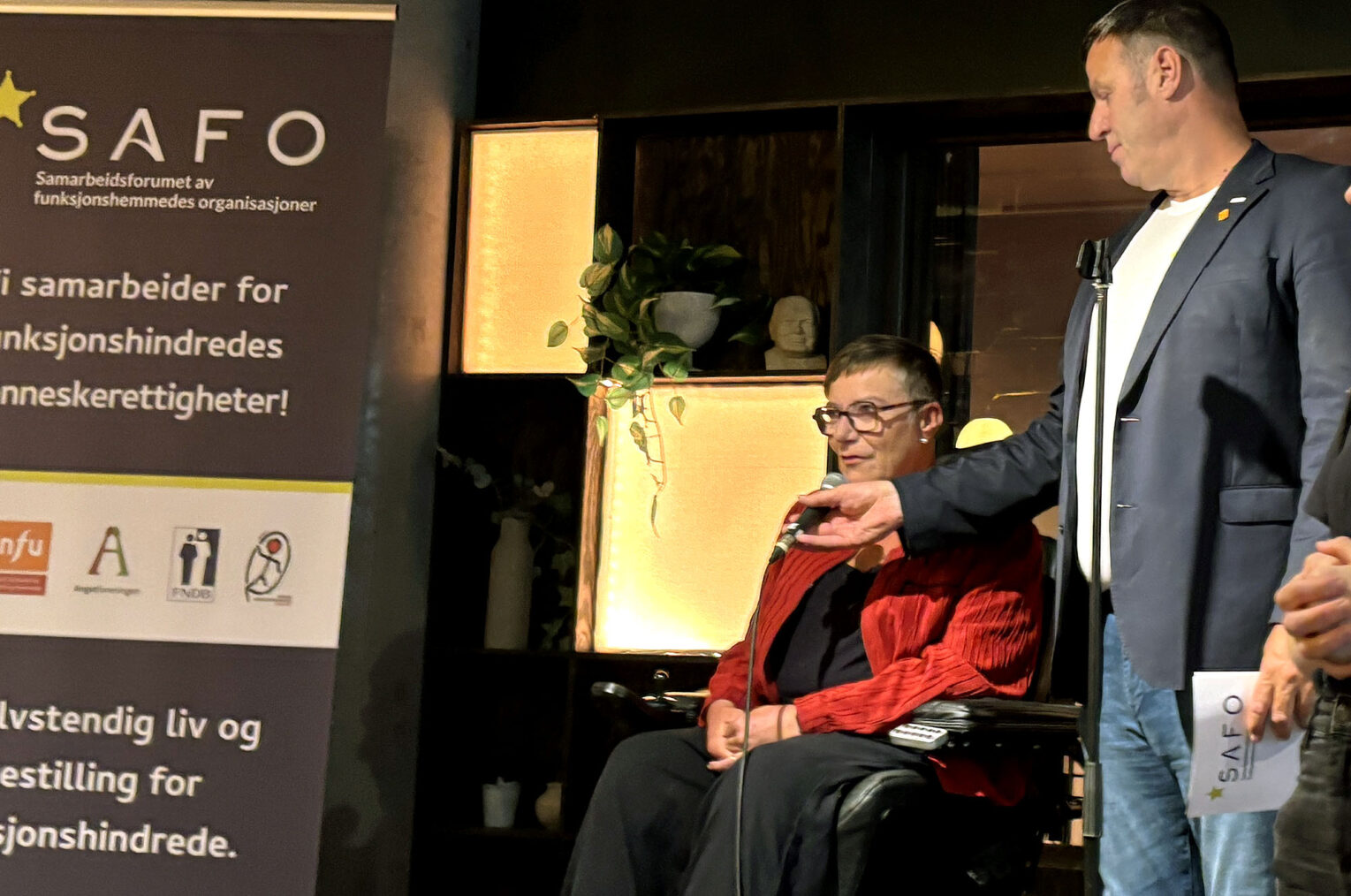 Tove Linnea Brandvik holder tale ved en SAFO-rollup. Tom Tvedt holder mikrofonen.