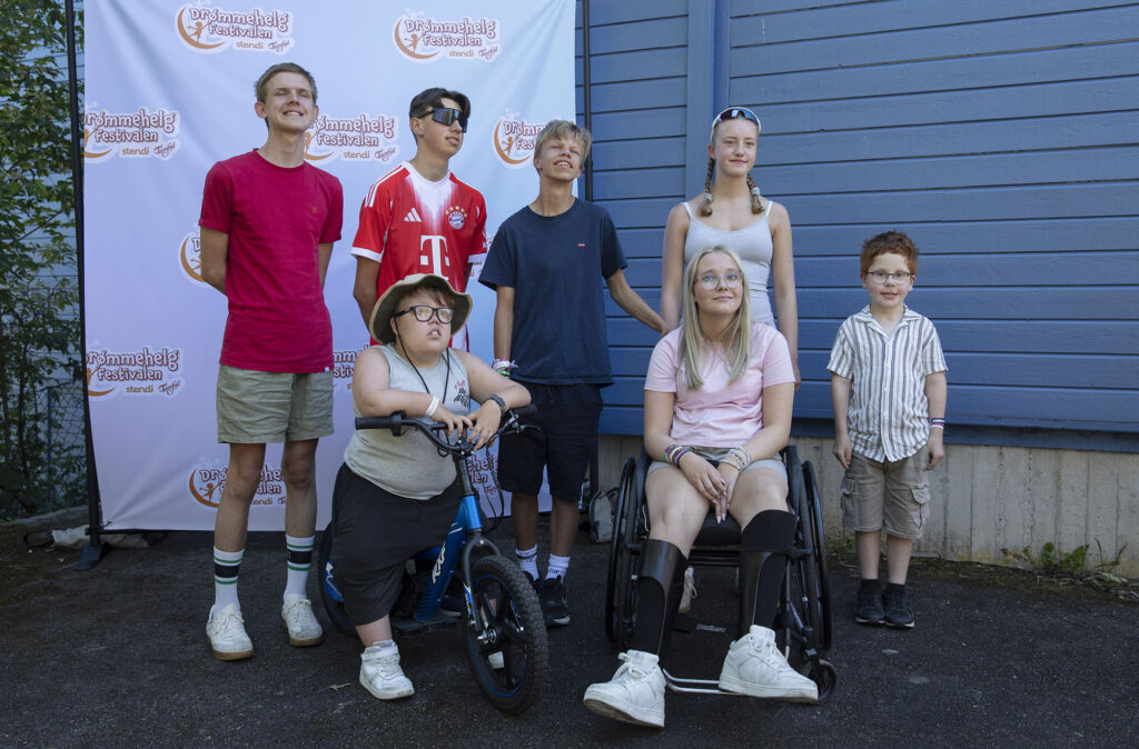 Gutt poserer sammen med Team Pølsa foran fotovegg