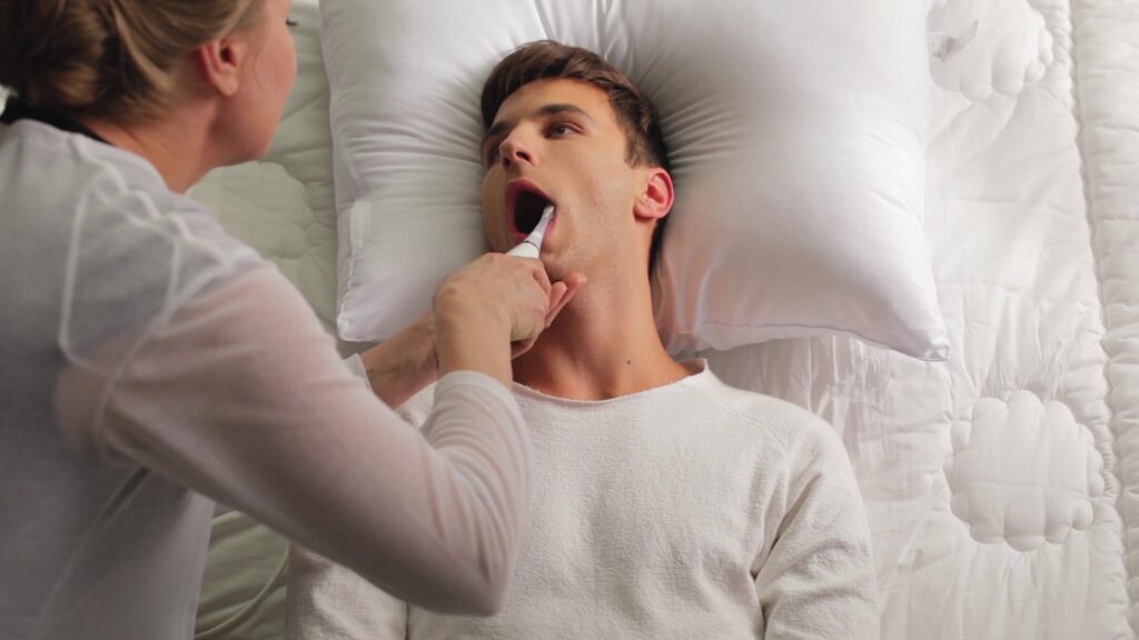 Kvinne pusser tennene til liggende mann