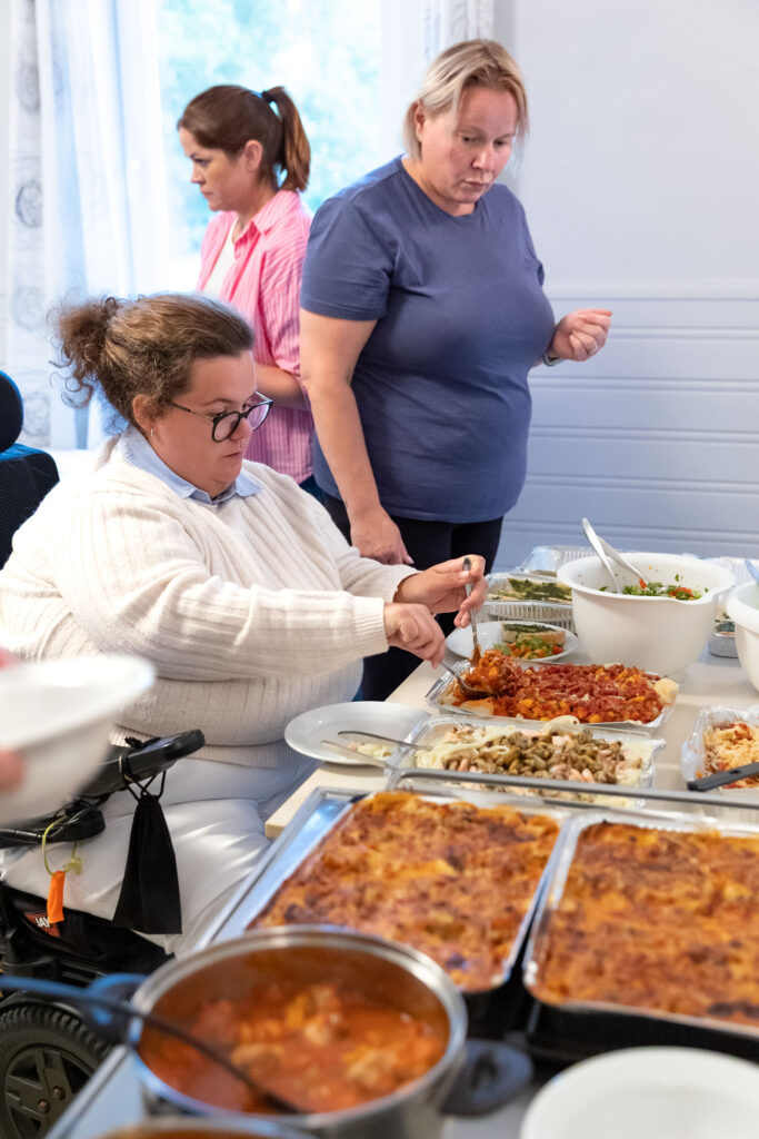 Kvinne i rullestol forsyner seg fra buffet