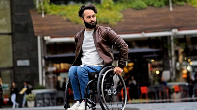 Mann i manuell rullestol foran uterestaurant
