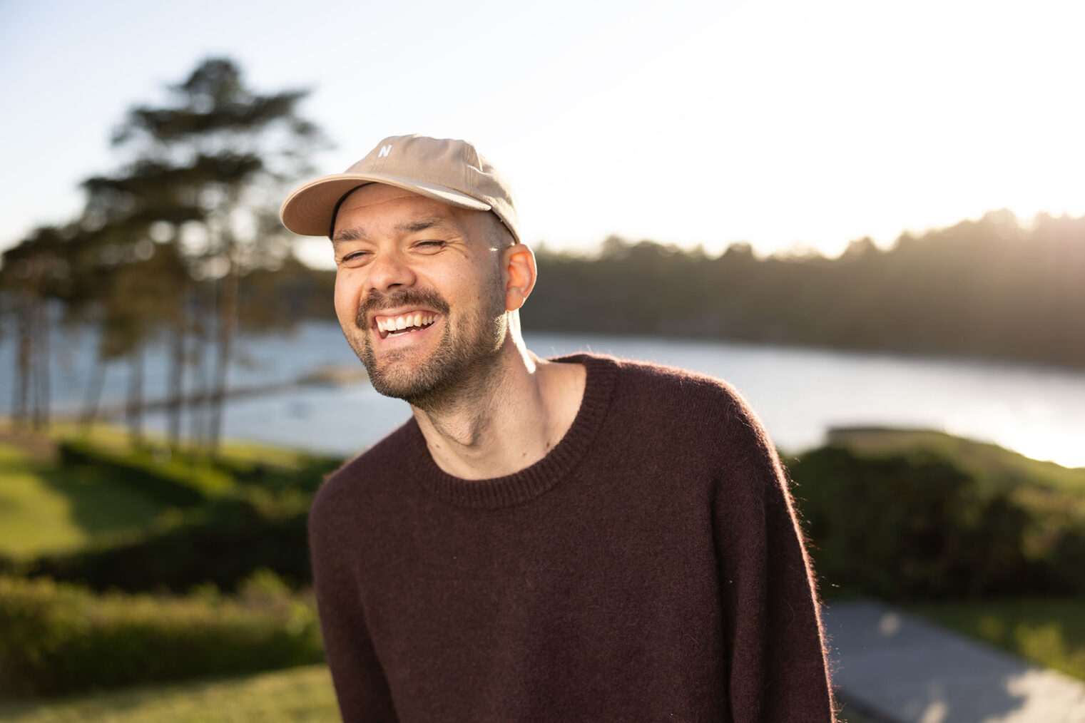 Smilende Lars Berrum med et vann i bakgrunnen