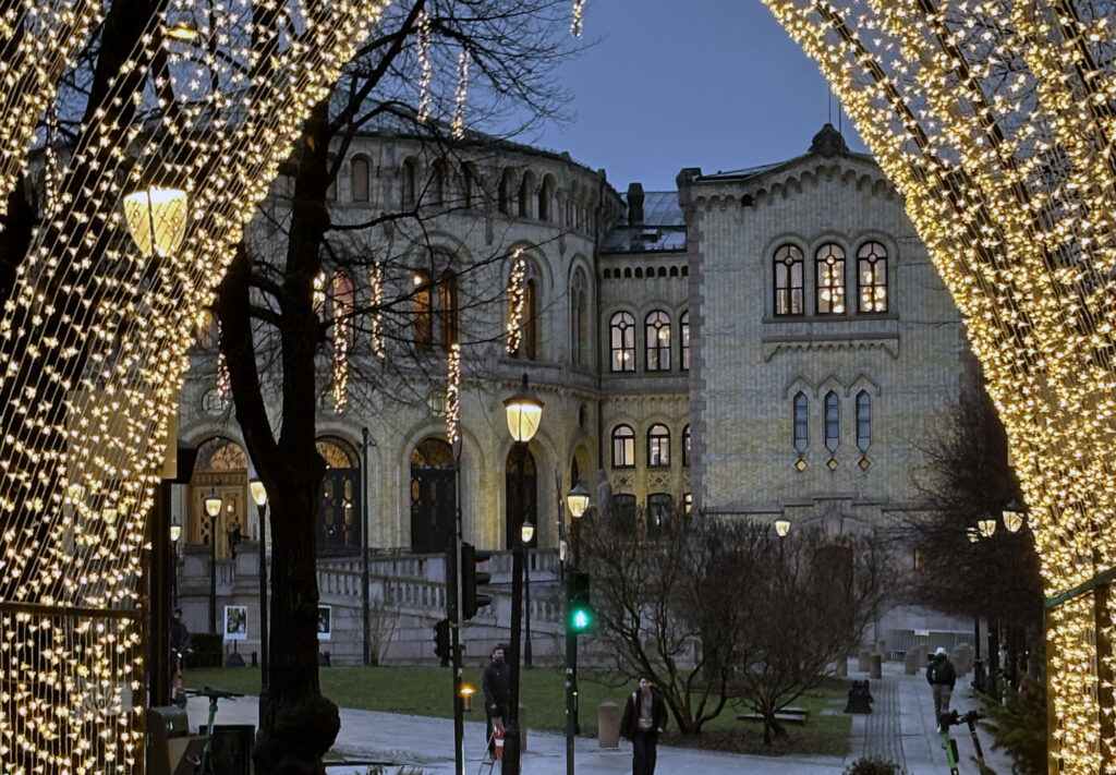 Stortinget sett fra julemarkedets tunnel av julelys