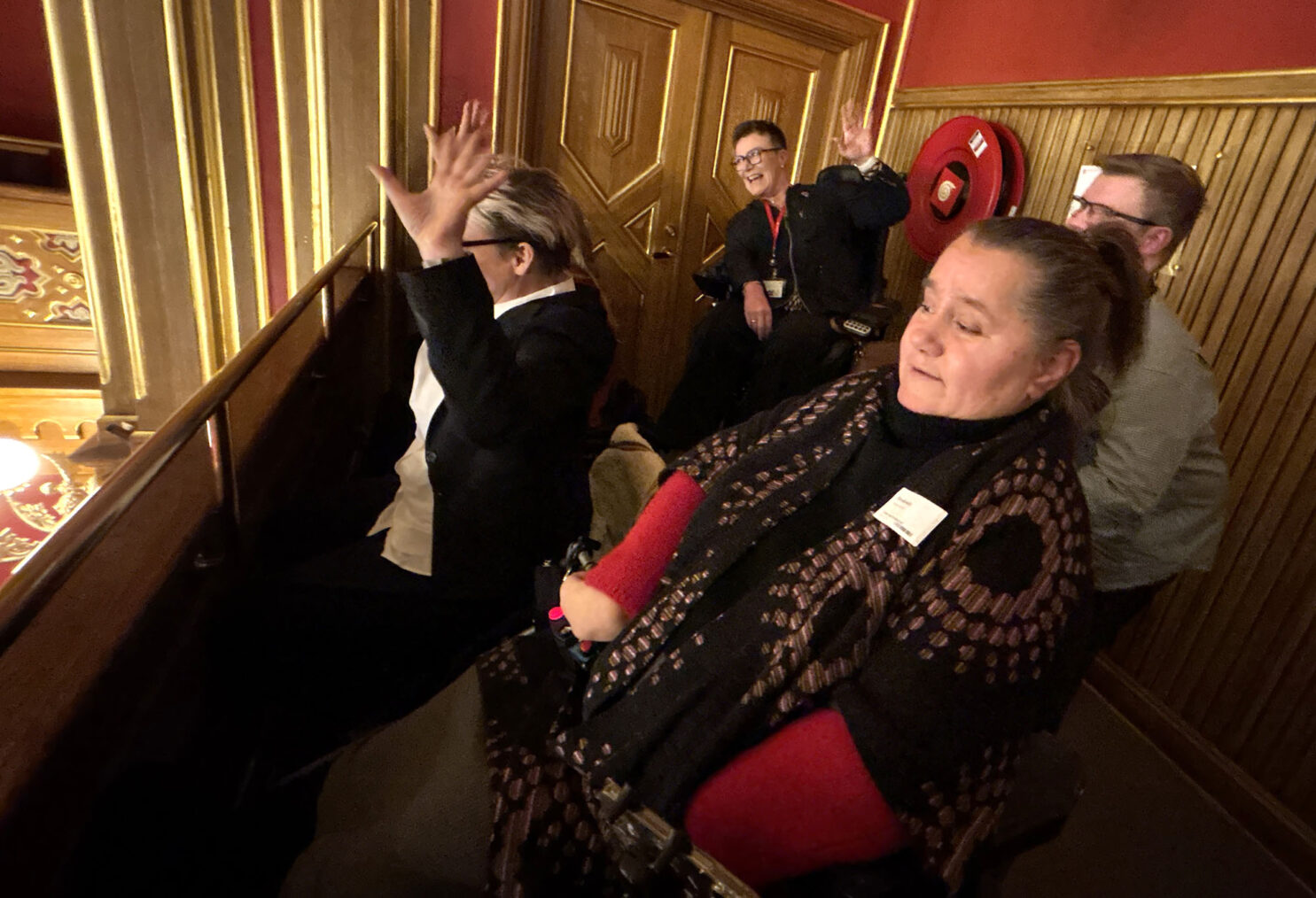 Funksjonshemmede på publikumsgalleriet på Stortinget vifter med hendene