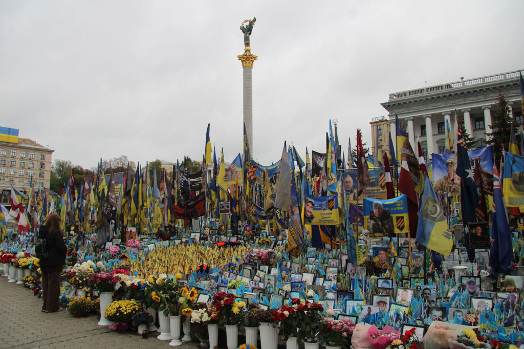 Mengder av friske blomsterbuketter, flagg og bilder på torg i Kyiv