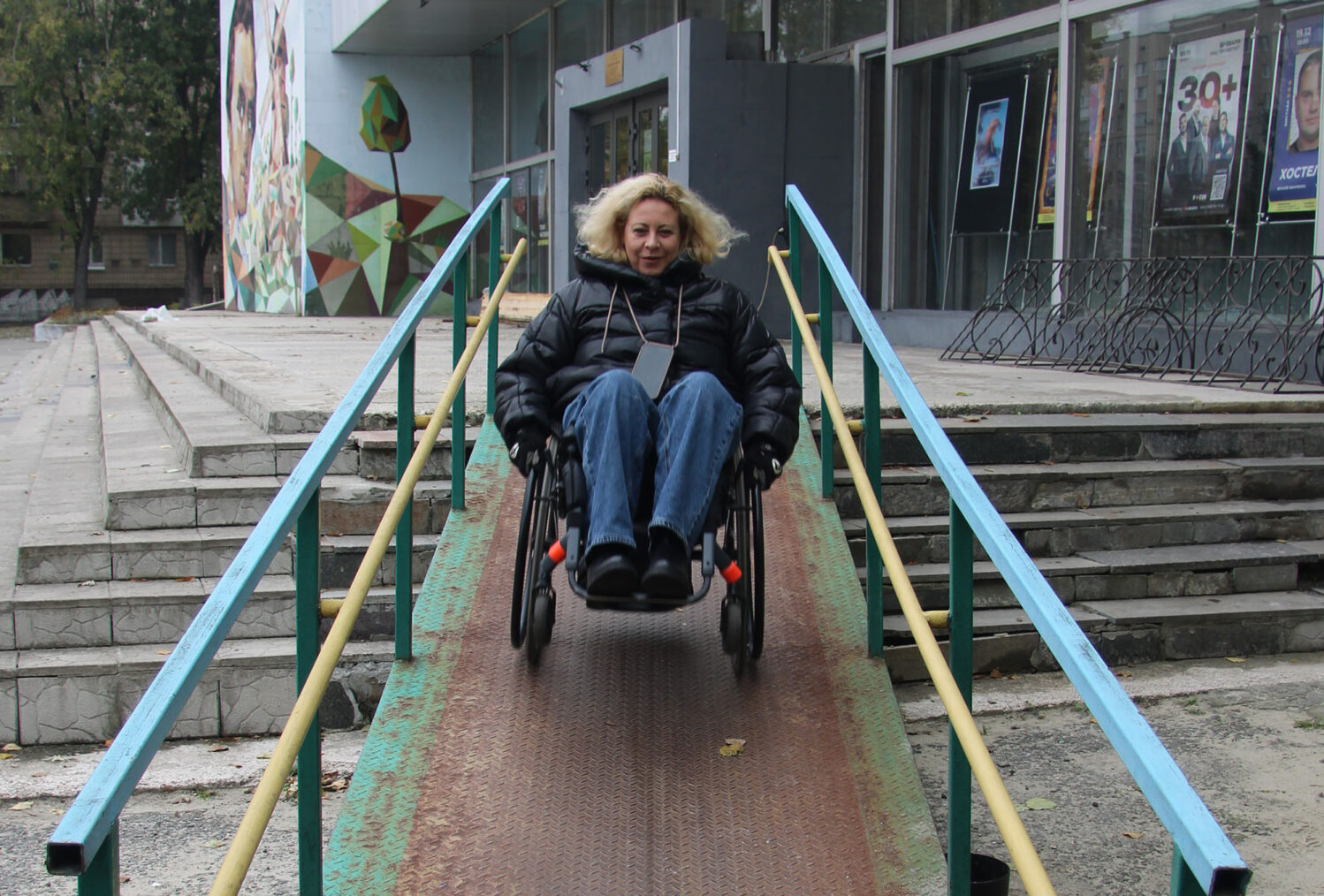 Olena Akopian i rullestol på vei ned rampe