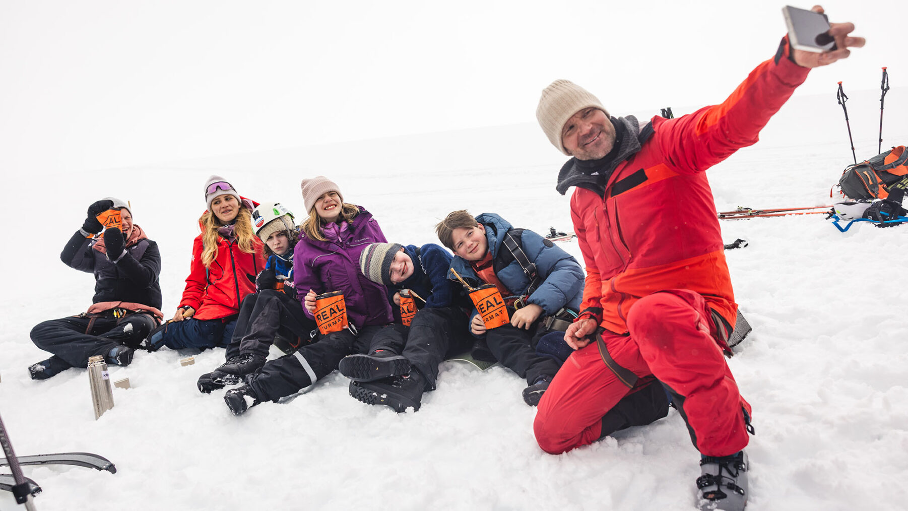 Øystein tar selfie sammen med seks funksjonshemmede ungdommer som har matpause på en bre.