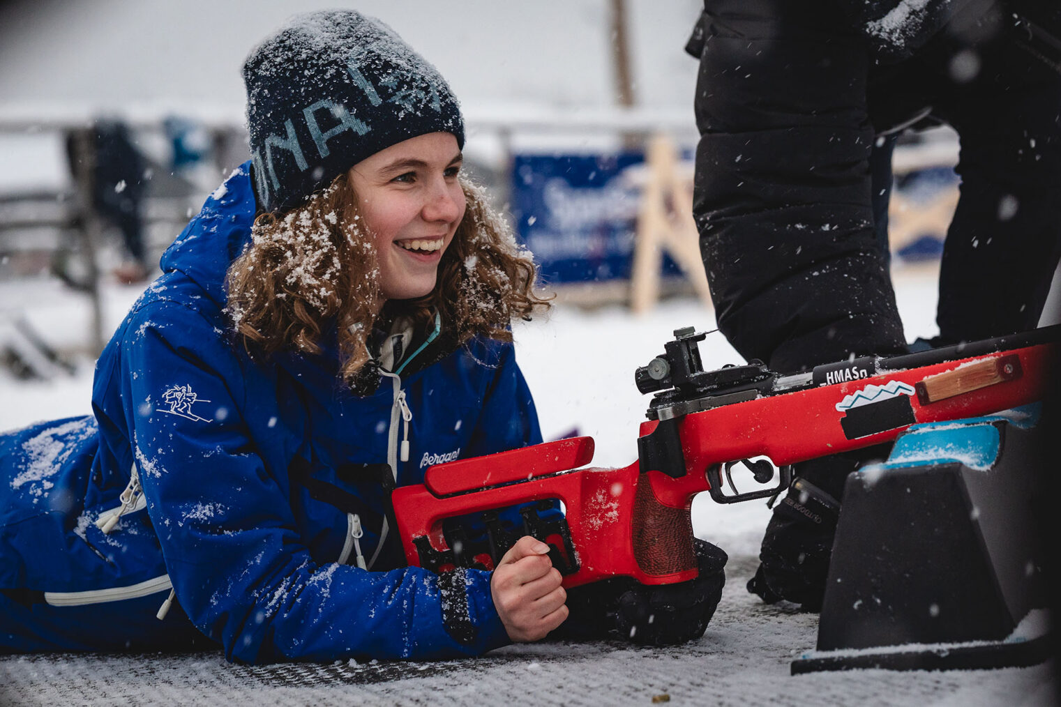 Synne Lykkeslet ligger med gevær på standplass i skiskyting