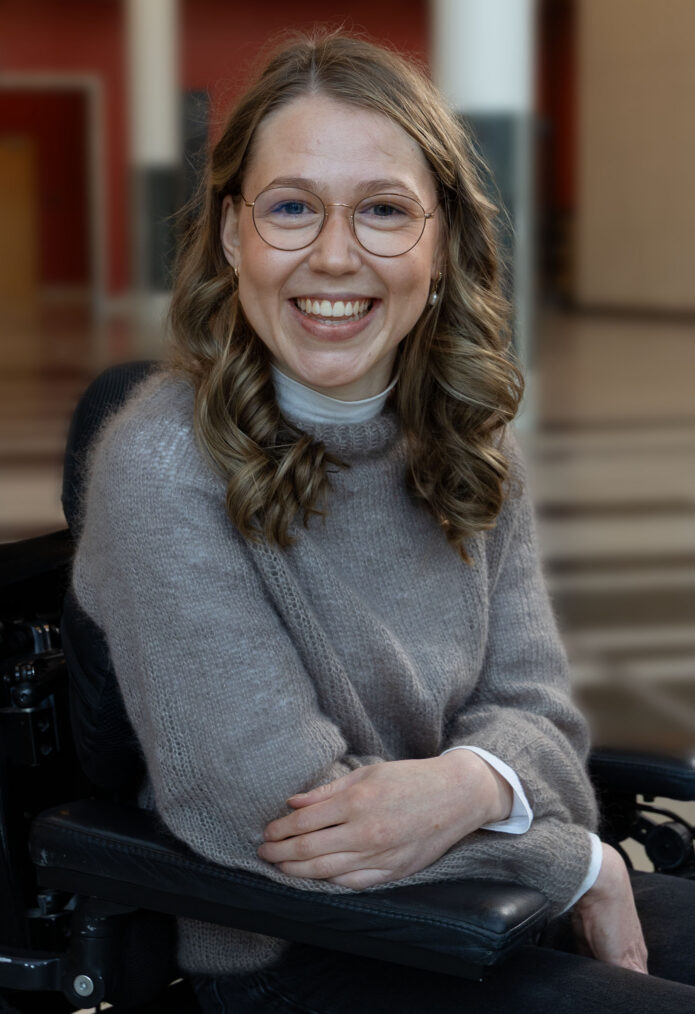 Marie Flaatten i elektrisk rullestol smiler til kameraet