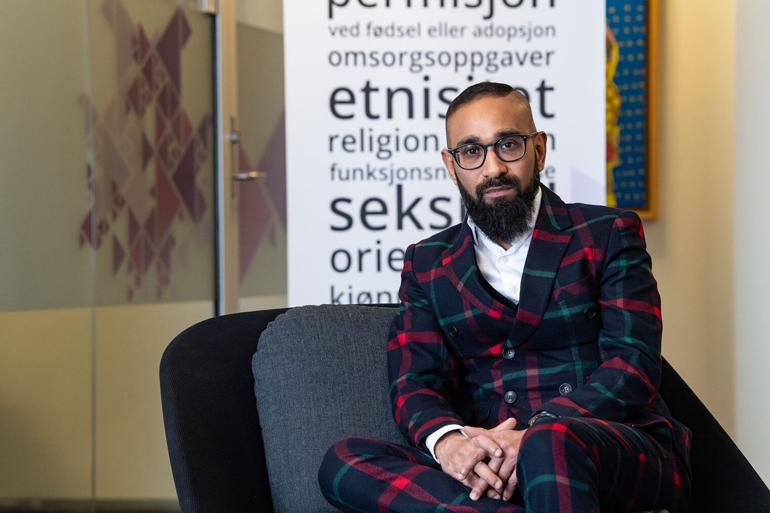 Ashan Nishantha foran plakat som lister opp diskrimineringsgrunnlag