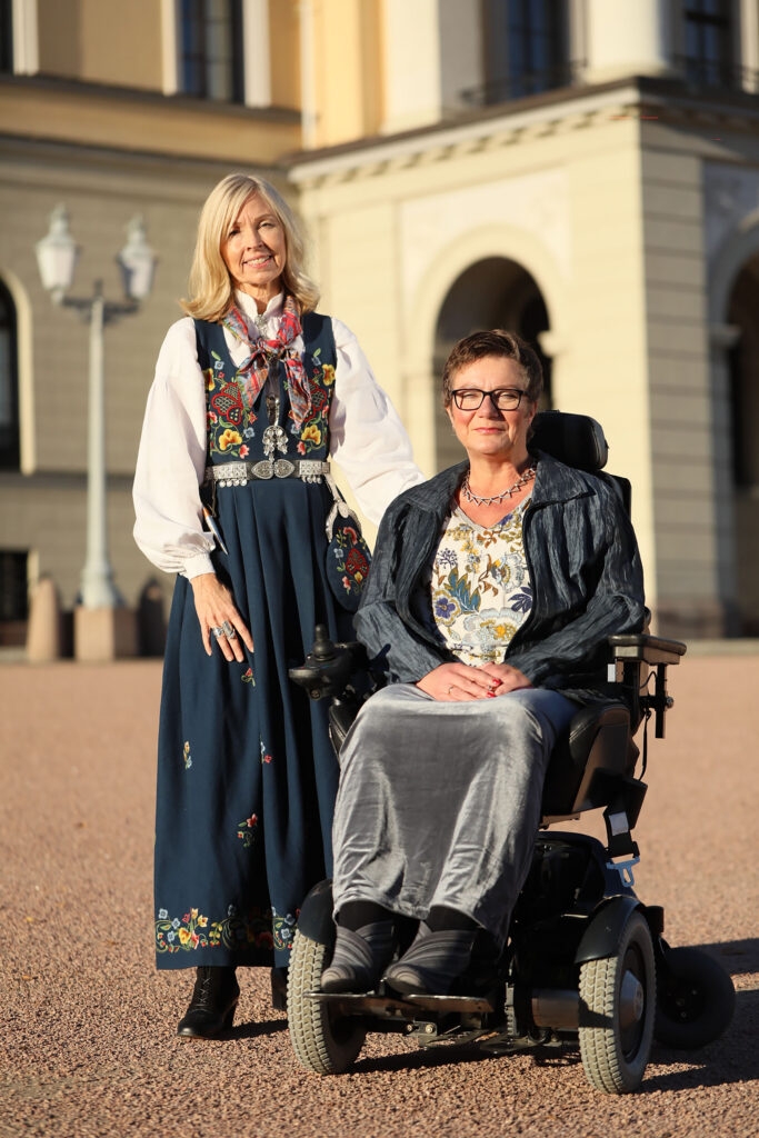 Astrid Nyquisr og Tove Linnea Brandvik i henholdsvis bunad og kjole foran slottet