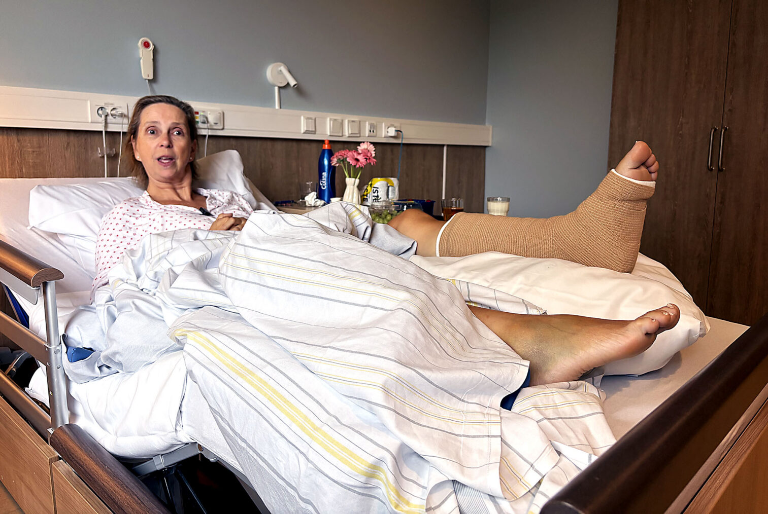 Tove Merete Hørgård i sykeseng med ett forslått og ett brukket bein